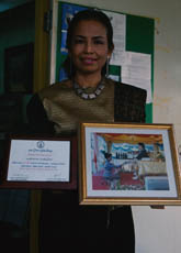 Tiyaphan Praphanvitaya shows a photograph in which she accepts, from the Royal Princess, Thailand's first prize in the lullaby competition that is conducted annually on Mother's Day