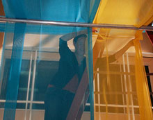 A museum volunteer installing the fabrics over the kiosks