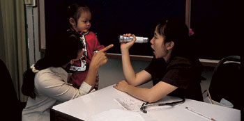 Woman entertains a small child with a flashlight