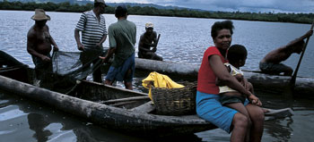 woman with child sits on the edge of a fishing  boat